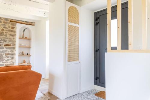 a living room with a black door and a couch at Maison des 11 Écluses-Vue sur le Canal d'Ille-et-Rance in Hédé
