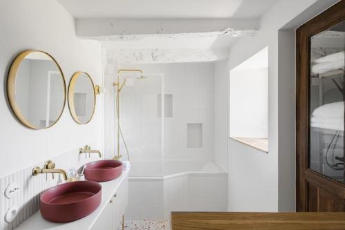 a bathroom with two red sinks and a tub at Maison des 11 Écluses-Vue sur le Canal d'Ille-et-Rance in Hédé