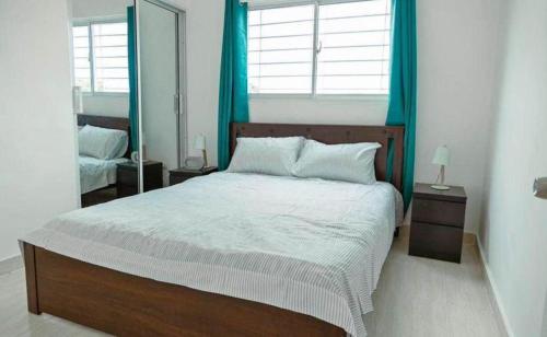Schlafzimmer mit einem großen Bett und blauen Vorhängen in der Unterkunft corona plaza in Santiago de los Caballeros