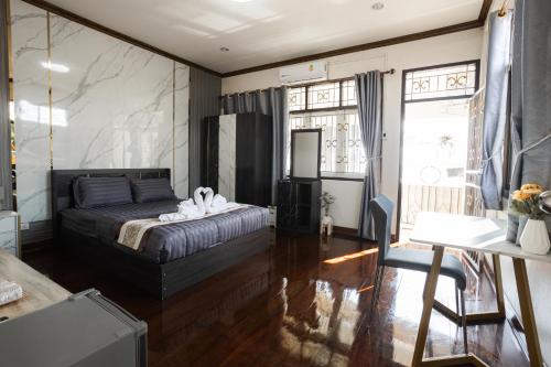 Schlafzimmer mit einem Bett, einem Tisch und Fenstern in der Unterkunft 2B Cozy Hostel ตรัง in Trang