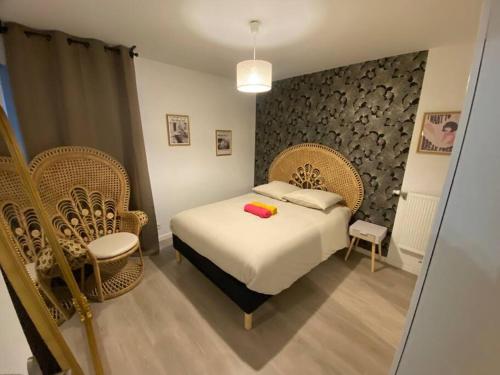 - une chambre avec un lit et des chaises en osier dans l'établissement Paris/Stade de France, parking sous-sol, à Aubervilliers