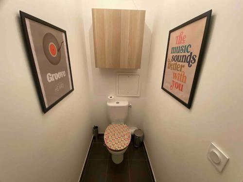 Elle comprend une petite salle de bains pourvue de toilettes et d'une affiche. dans l'établissement Paris/Stade de France, parking sous-sol, à Aubervilliers