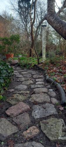 a stone path in a garden with a tree at Einfachlosmachen-Zeltpunkt in Aulosen