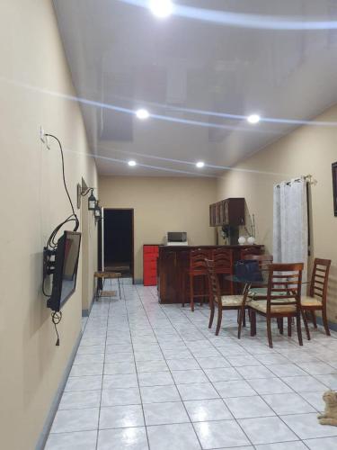 un soggiorno con tavolo e sedie e una cucina di Ixoras Guest House a Moyogalpa