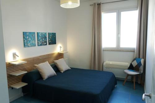 een slaapkamer met een blauw bed en een raam bij Orizzonte Blu apartment - Macari Bay in Macari