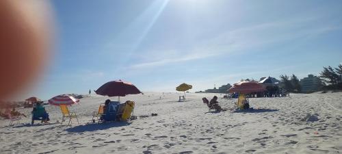 a beach with umbrellas and chairs and people on it at MANDAI Apartamento Cabo Frio in Cabo Frio