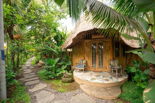 a small hut with two chairs and a porch at Ubud Art Resort in Ubud