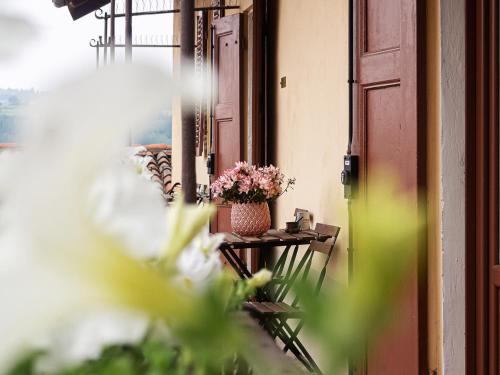 a room with a vase of flowers on a table at Raviola e Tajarin in Verduno