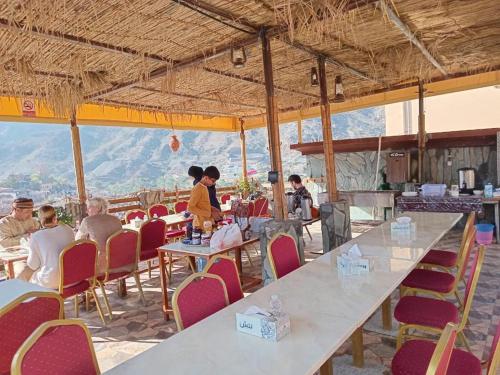 a group of people sitting at tables in a restaurant at Guest house baldsayt in Bilād Sayt