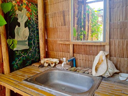 baño de madera con lavabo y ventana en BH Beachfront Mini Glamping Tent, en El Nido