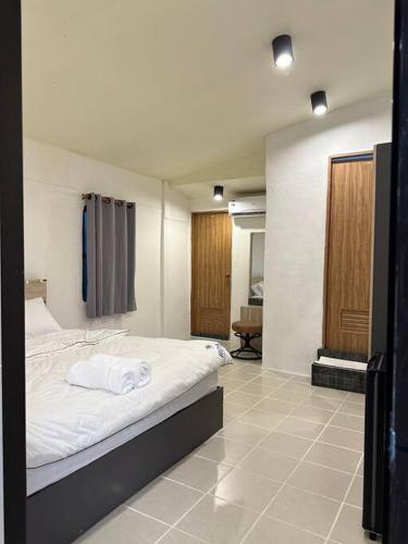 a bedroom with a white bed in a room at Chubby 5 Room 5 in Bangkok