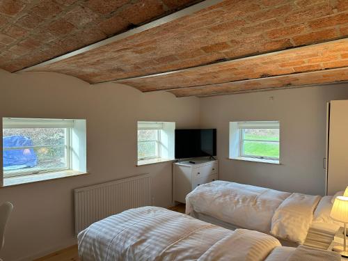 1 dormitorio con 2 camas y TV de pantalla plana en Solbjerg Skov B&B, en Solbjerg