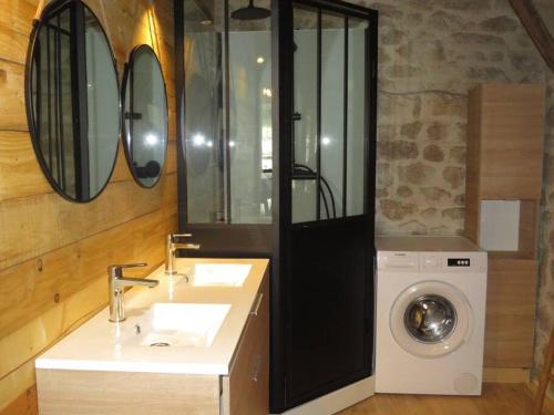 une salle de bain avec un lavabo et une machine à laver dans l'établissement Gîte 5 personnes en Ardèche, à Beauvène