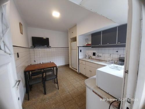 a kitchen with a table and a small table and a refrigerator at Ph Sil Con patio y cochera!!! in Mar del Plata