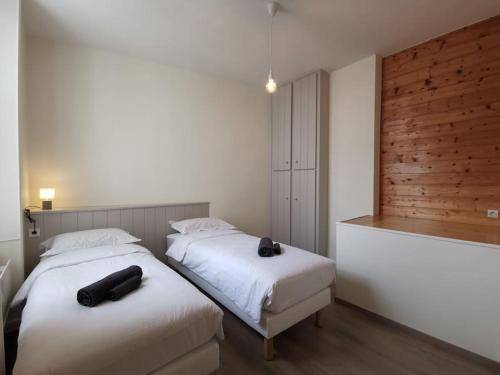 - deux lits dans une chambre avec deux objets noirs dans l'établissement La perle de Ré au cœur de Saint Martin, à Saint-Martin-de-Ré