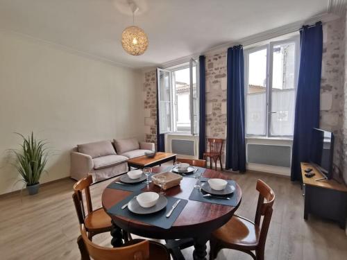 un salon avec une table, des chaises et un canapé dans l'établissement La perle de Ré au cœur de Saint Martin, à Saint-Martin-de-Ré