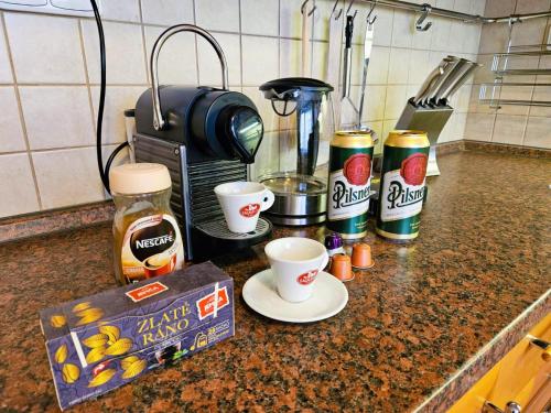 a kitchen counter with a coffee maker and coffee cups at Sunny & Spacious, 10mins to Centre, Free parking, Quiet location, New Furniture, Balcony in Prague