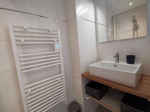 une salle de bain blanche avec un lavabo et un miroir dans l'établissement La perle de Ré au cœur de Saint Martin, à Saint-Martin-de-Ré