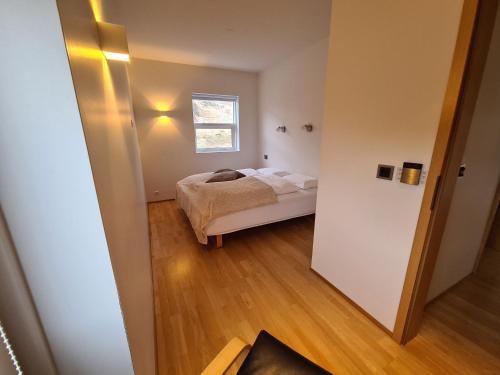 a small bedroom with a bed and a window at Geithellar in Djúpivogur