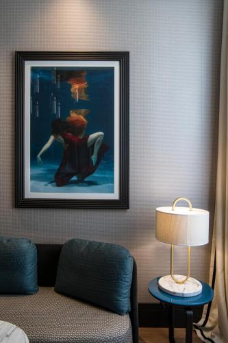 a hotel room with a painting on the wall and a lamp at Umiltà 36 in Rome