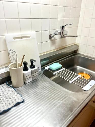 a kitchen sink with a strainer next to it at ᛃ 眠りの癒 ᛃ Cozy Stay In The Heart of Beppu Apt 202 in Beppu