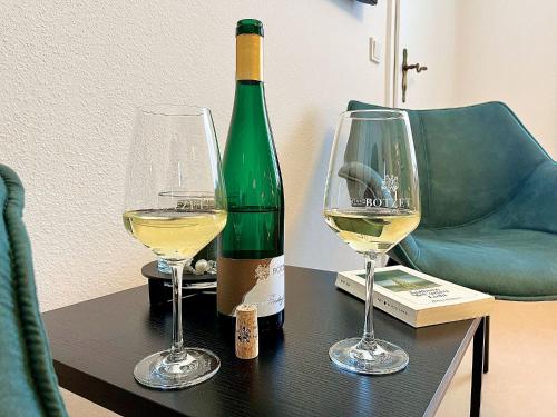 a bottle of wine and two glasses on a table at Pension 1595 im Weingut Botzet in Maring-Noviand
