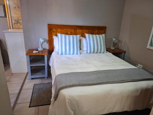 a bedroom with a large bed with blue and white pillows at 1@Kruger in Mokopane