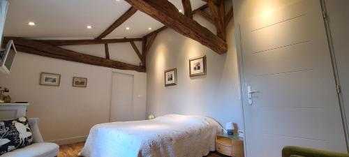 a bedroom with a white bed and a wooden ceiling at Izzys in Champagné-les-Marais