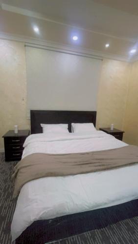 a bedroom with a large bed with white sheets and pillows at سويت فندقي Hotel suite in AlUla
