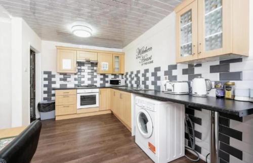 a kitchen with a black and white checkered wall at 1 bedroom flat in Luton free parking in Luton