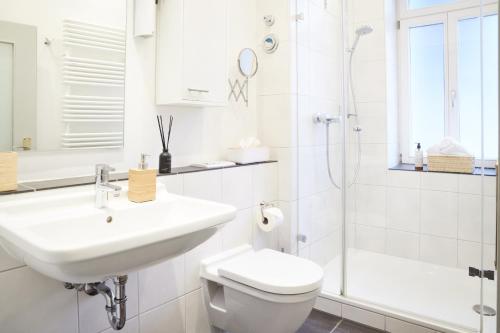a bathroom with a sink and a toilet and a shower at IDEE Living: Altstadt-Apartment im Herzen d. Pfalz in Neustadt an der Weinstraße