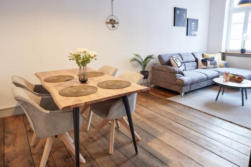 a living room with a wooden table and chairs at UPPER ROOM Altstadt-Apartment im Herzen der Pfalz in Neustadt an der Weinstraße