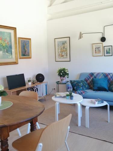 a living room with a blue couch and tables at La Petite Maison in Villeconin