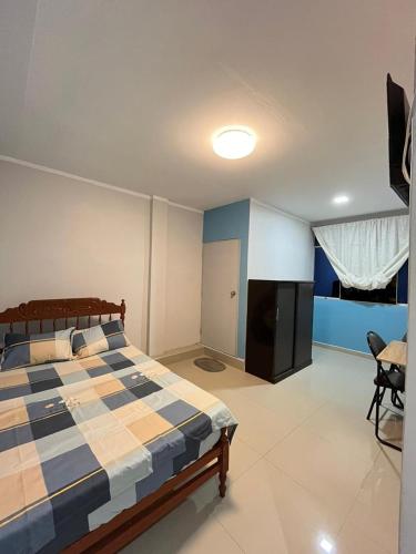 1 dormitorio con 1 cama azul y blanco en Condominio Confortable en Talara