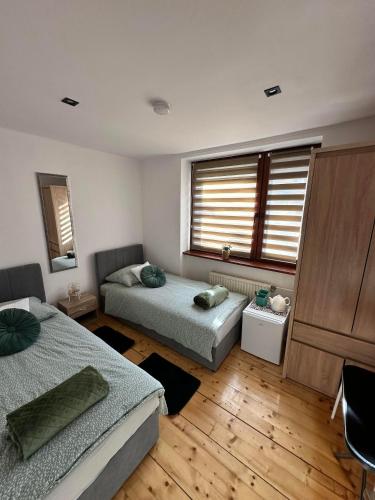 a bedroom with two beds and a window at Villa na Dolnej in Karpacz