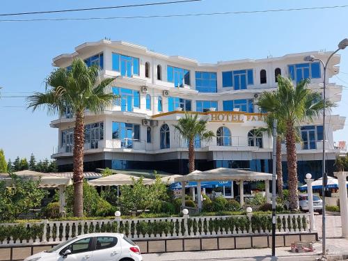 un hôtel avec des palmiers devant lui dans l'établissement Fari Hotel, à Golem