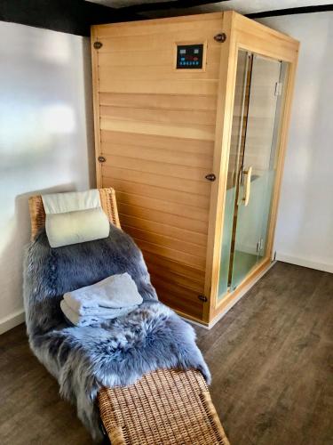 a wicker chair with a faux fur seat in front of a door at Ferienhaus Eifel-Auszeit in Rieden