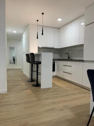 a kitchen with white cabinets and a black table at Central Аpartment Foca with garage in Foča