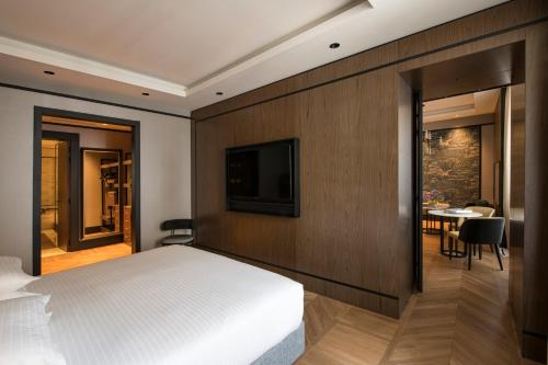 a bedroom with a bed and a tv and a table at Umiltà 36 in Rome