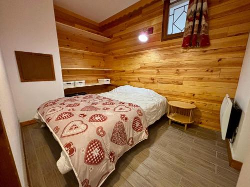 ラ・ジュー・デュ・ルーにあるRésidence les monts du soleilの木製の壁のベッドルーム1室(ベッド1台付)