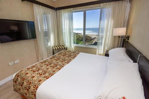 a hotel room with a bed and a large window at Marcin Hotel in Carilo