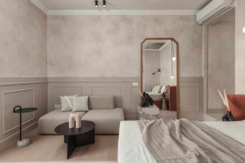 una camera con letto, divano e specchio di Luxury Suites by Lato ad Ágios Nikólaos