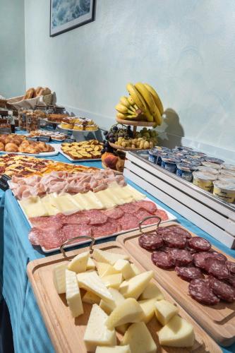 a table filled with cheese and meats and other foods at Hotel Acrux in Gabicce Mare