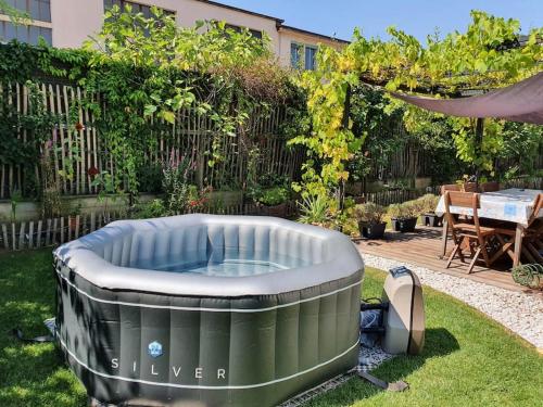 Appart. 3 chambres, jacuzzi en été, dans un jardin في جنيف: حديقة خلفية مع حوض استحمام ساخن في العشب
