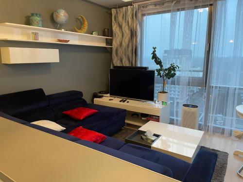 a living room with a blue couch and a tv at Tacoma apartamenty in Warsaw