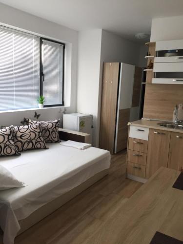 a small bedroom with a bed and a kitchen at Studio Zori in Burgas City