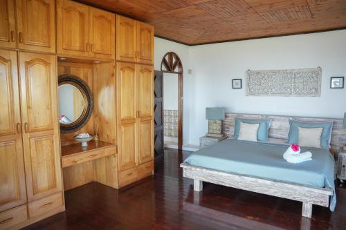 a bedroom with a blue bed and a mirror at Beau Soleil Stunning Sea View One Bedroom Apartment in Mahe