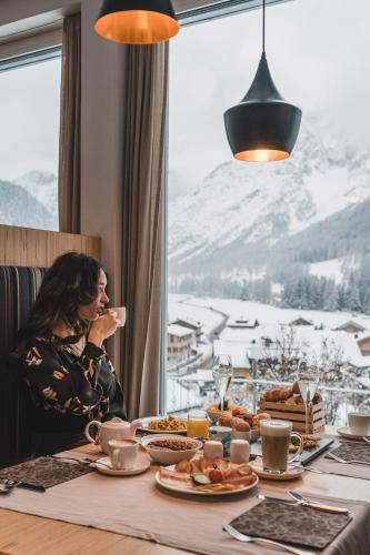 a woman sitting at a table with breakfast food at Hotel Royal in Sesto