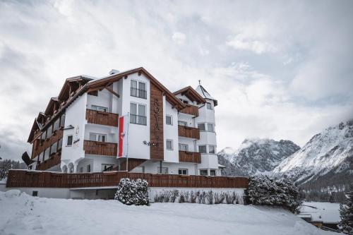 a hotel in the mountains in the snow at Hotel Royal in Sesto