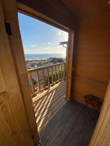 a room with a balcony with a view of the ocean at Hostal F in El Quisco